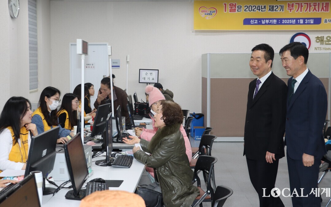 이동운(사진 왼쪽) 부산지방국세청장이 지난해 하반기 부가가치세 신고기간인 20일 해운대세무서 민원실을 불시에 방문, 직원들의 민원인 응대상황을 웃으며 살펴보고 있다. 
  부산국세청 제공