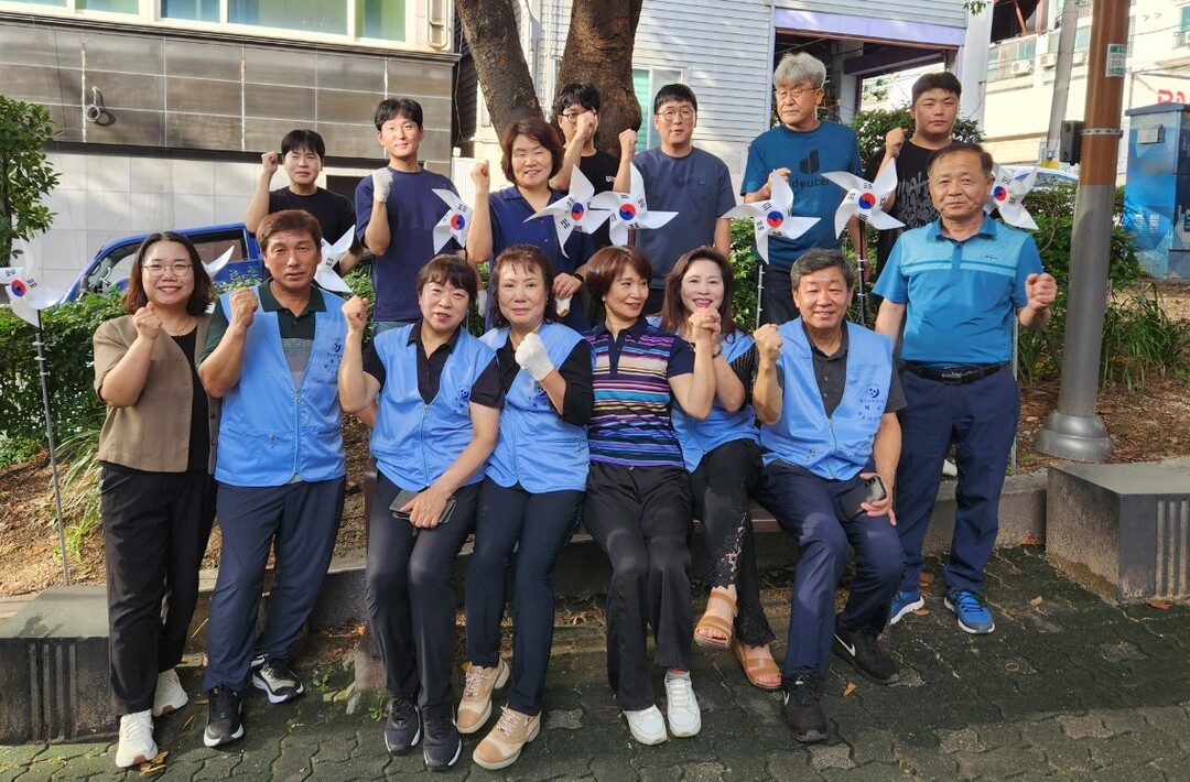 부산 북구 구포3동 행정복지센터와 구포3동 청소년지도협의회 회원들이 공동으로 지난 13일 관내 포천사거리 쌈지공원에서 ‘나라사랑 태극기 달기 운동’을 전개한 뒤 기념촬영을 하며 파이팅을 외치고 있다.  북구청 제공
