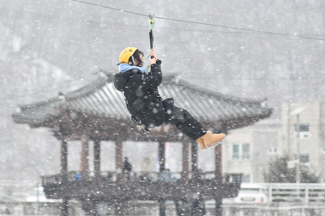 2026 화천산천어축제 개막 사흘째인 12일, 함박눈이 내리는 가운데 관광객들이 짚라인 체험을 즐기고 있다. 


